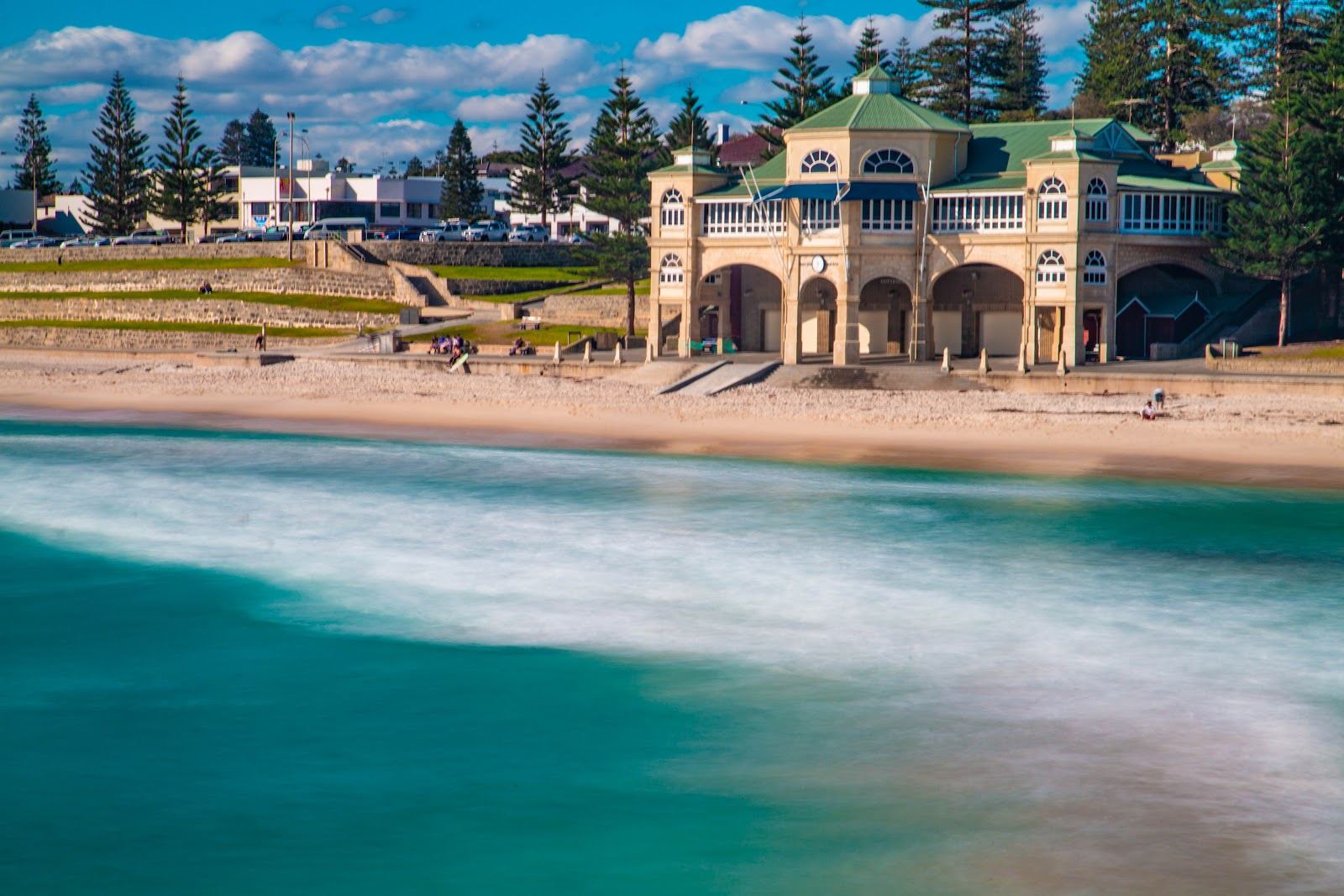 Wide free public sand and clear water at Cottesloe Beach in Perth at low light.