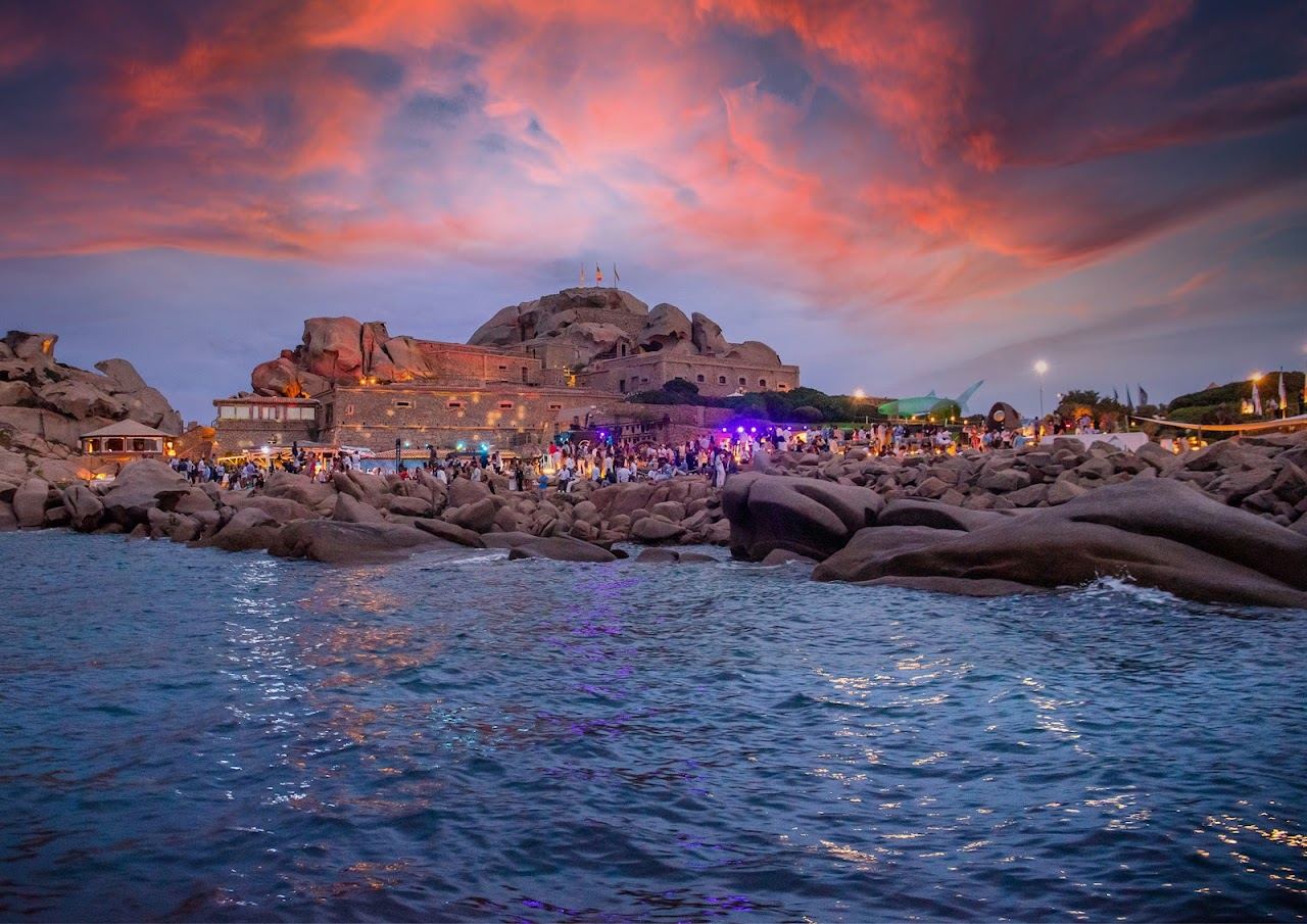 Sunbeds and umbrellas layered over the granite rocks of Phi Beach at Forte Cappellini, Baja Sardinia