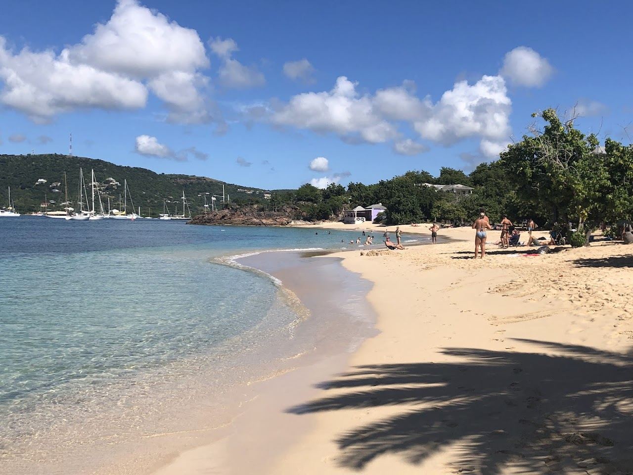 The calm turquoise water and golden sand of Pigeon Point Beach beside Falmouth Harbour in Antigua