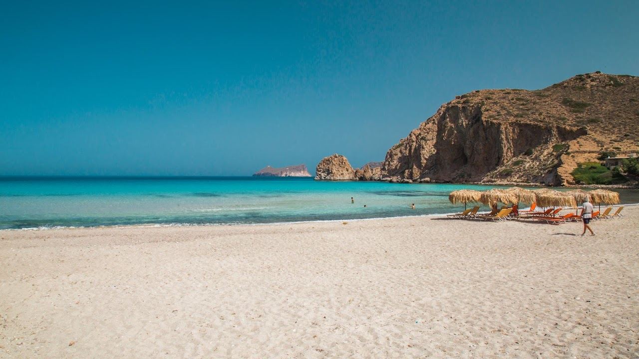 The sheltered sandy bay of Plathiena with calm water and tamarisk trees and no large beach club on the northwest coast of Milos