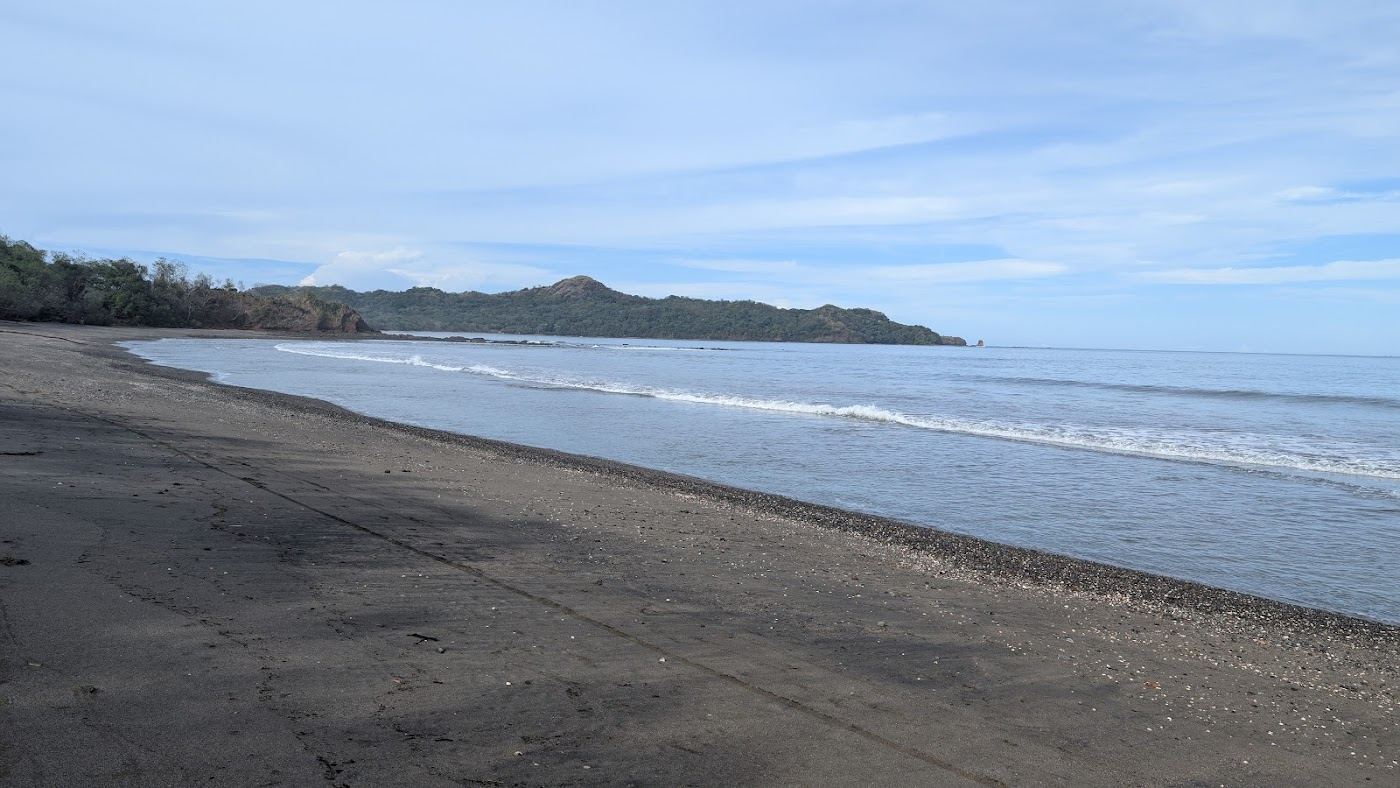 Pale shell sand meeting calm turquoise sea at Playa Conchal near Brasilito
