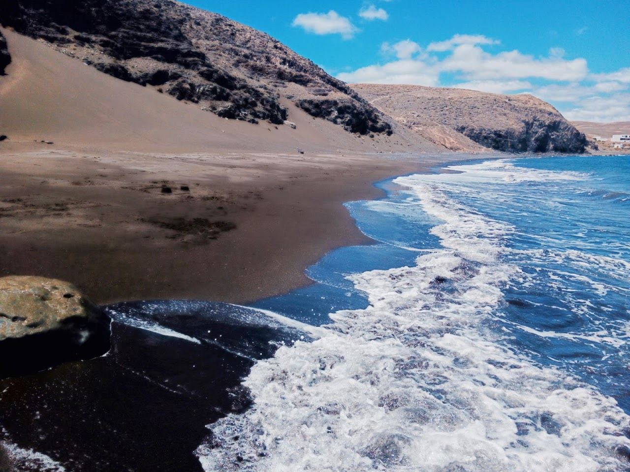 Calm black sand cove below the fishing village of Playa Quemada in southern Lanzarote