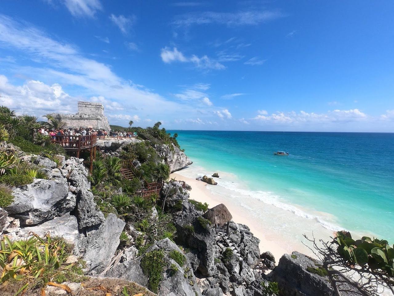 The small cove of Playa Ruinas with turquoise water beneath the clifftop Tulum ruins
