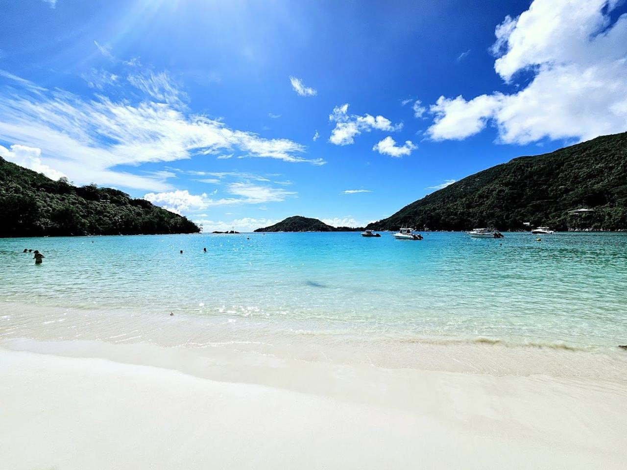 Calm sheltered water and palm backed sand at Port Launay inside the marine park on north west Mahe in Seychelles