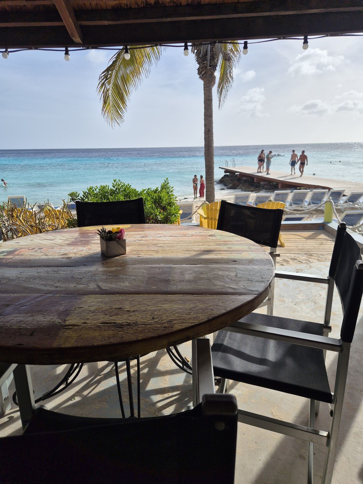 The beach bar and pier setting behind the sand at Playa Porto Mari in Curacao