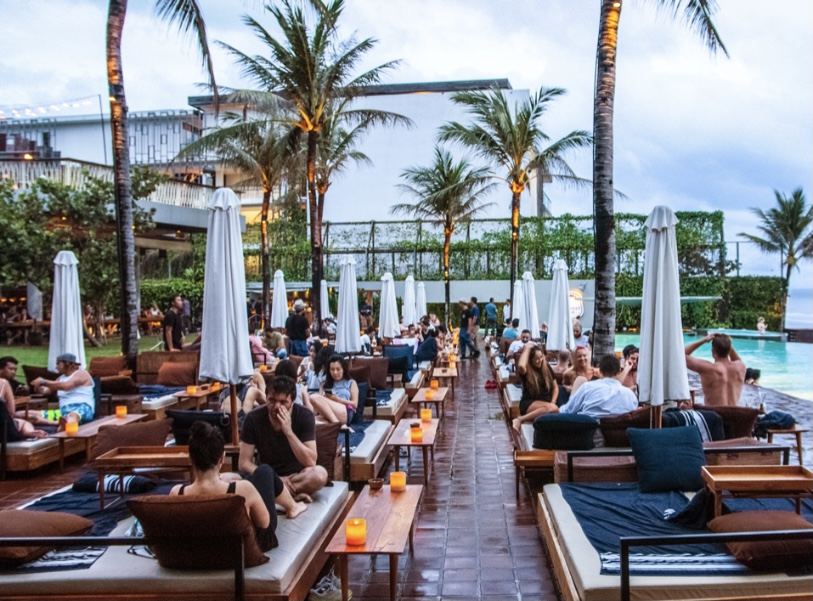 The daybeds, lawn and saltwater pool of Potato Head Beach Club facing the sea at Seminyak, Bali