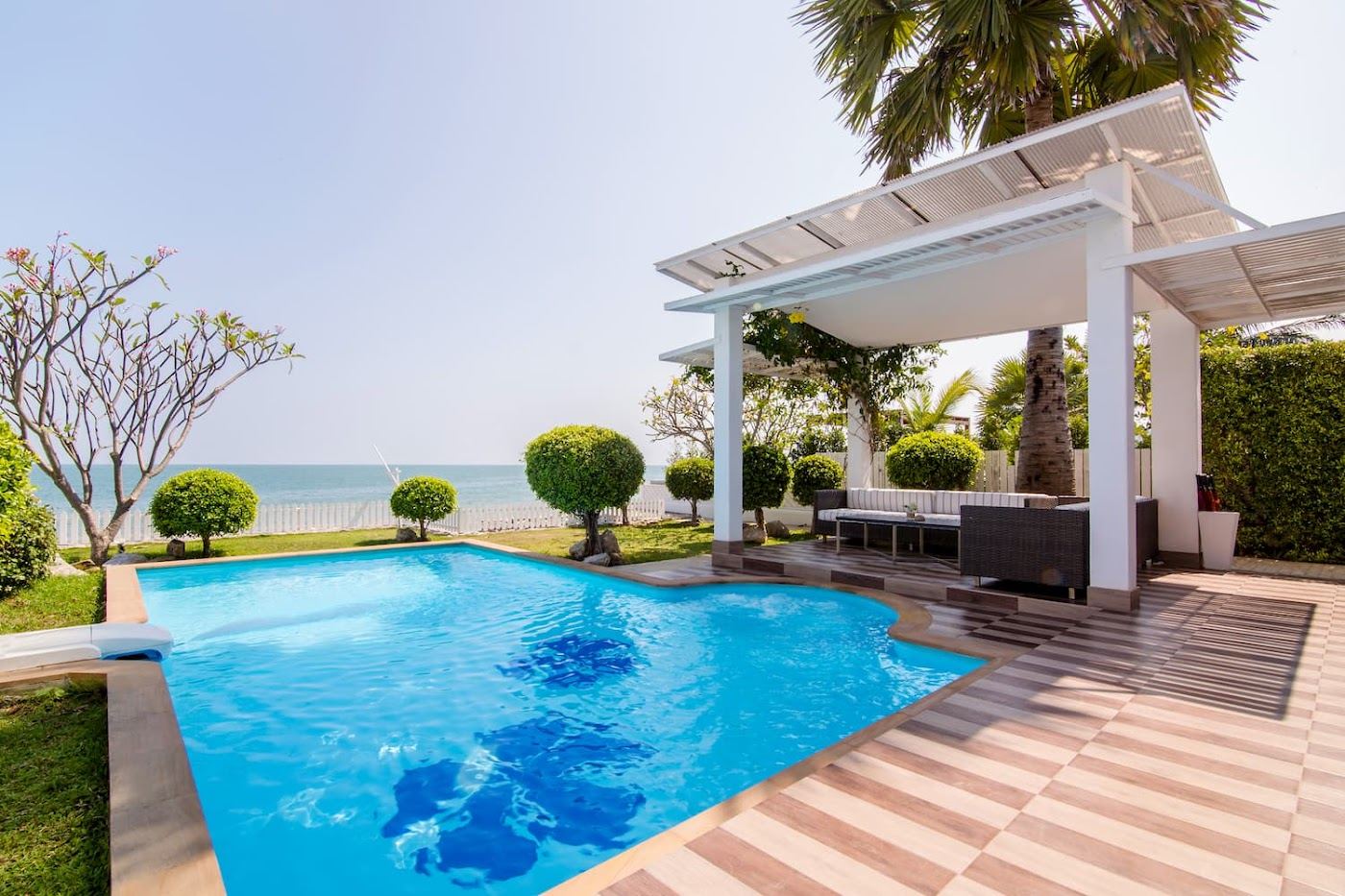 The beachfront pool and sand setting at Aleenta Hua Hin Pranburi resort on Pranburi Beach