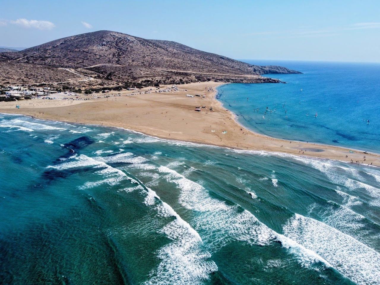 Wide sandbar at Prasonisi where a calm sea and a windy sea meet at the southern tip of Rhodes with kitesurfers on the water