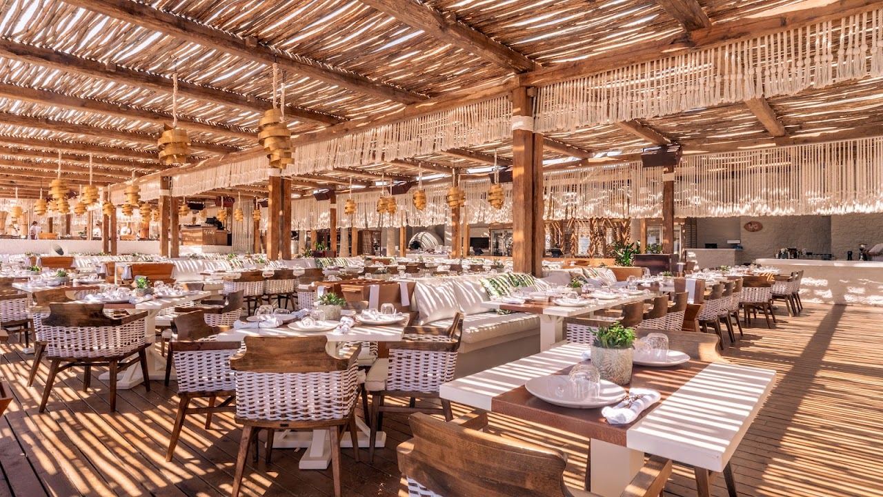 Umbrellas and reserved loungers on the sand at Principote beach club on Panormos bay in Mykonos