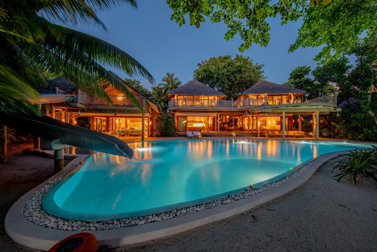 White sand and villas among trees at Soneva Fushi in the Maldives