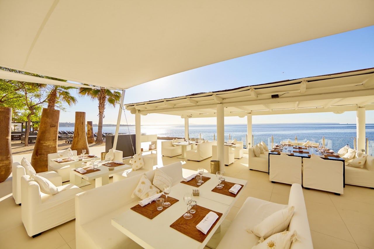 Tiered white terraces and daybeds of Purobeach Illetas on the cliff above the Illetas coves