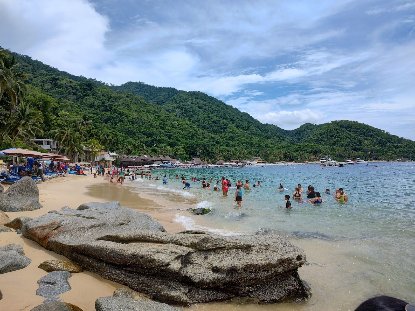 Boats and swimmers in the sheltered water off a south shore beach in the Bay of Banderas, Puerto Vallarta
