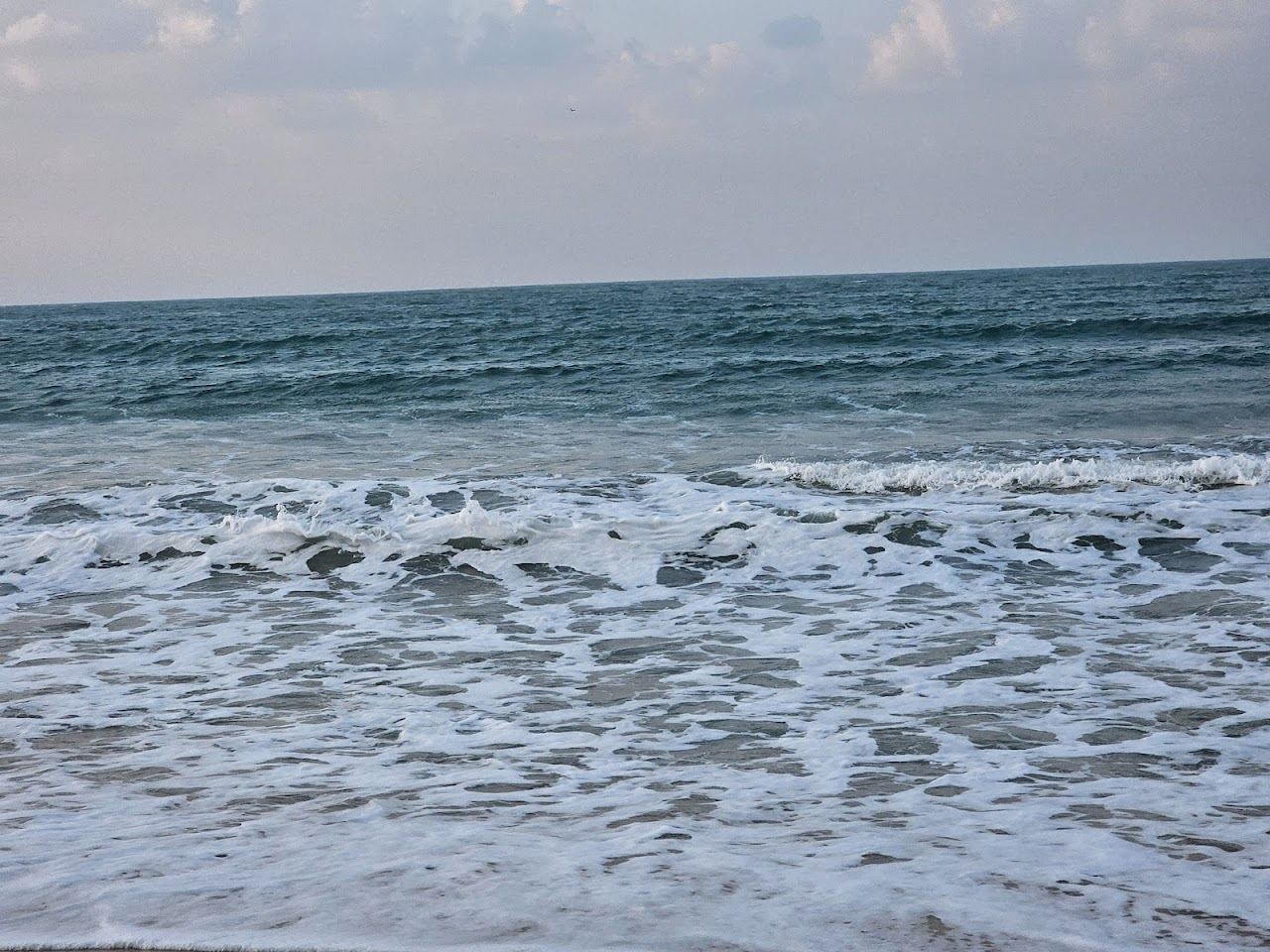 Calm sheltered Gulf water and soft sand on a quiet shore in Ras Al Khaimah
