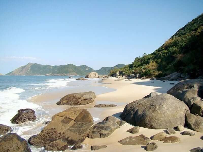 Pale wild sand and green hills at Grumari beach in western Rio de Janeiro