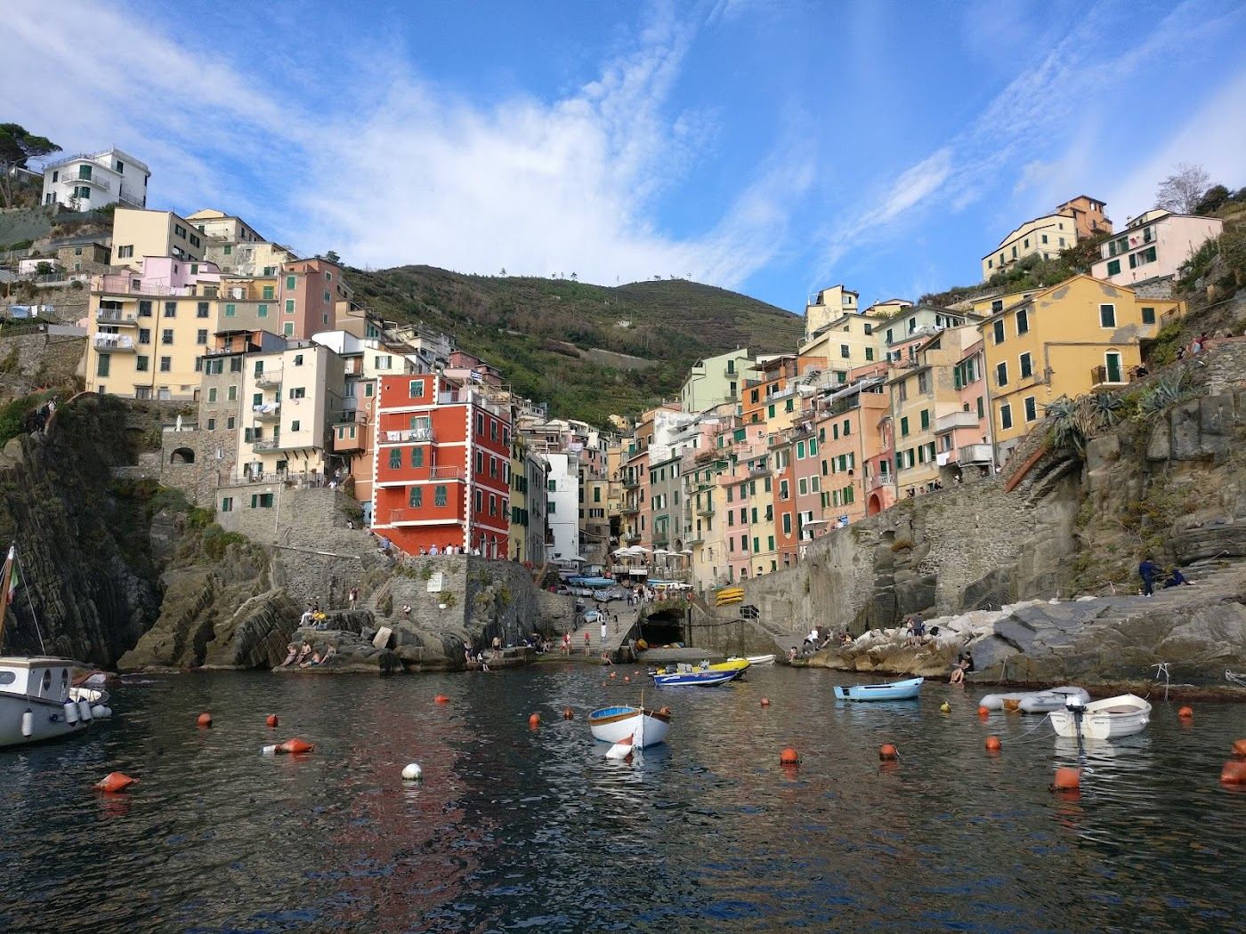 Boats and the small harbour of Riomaggiore below its stacked Cinque Terre houses