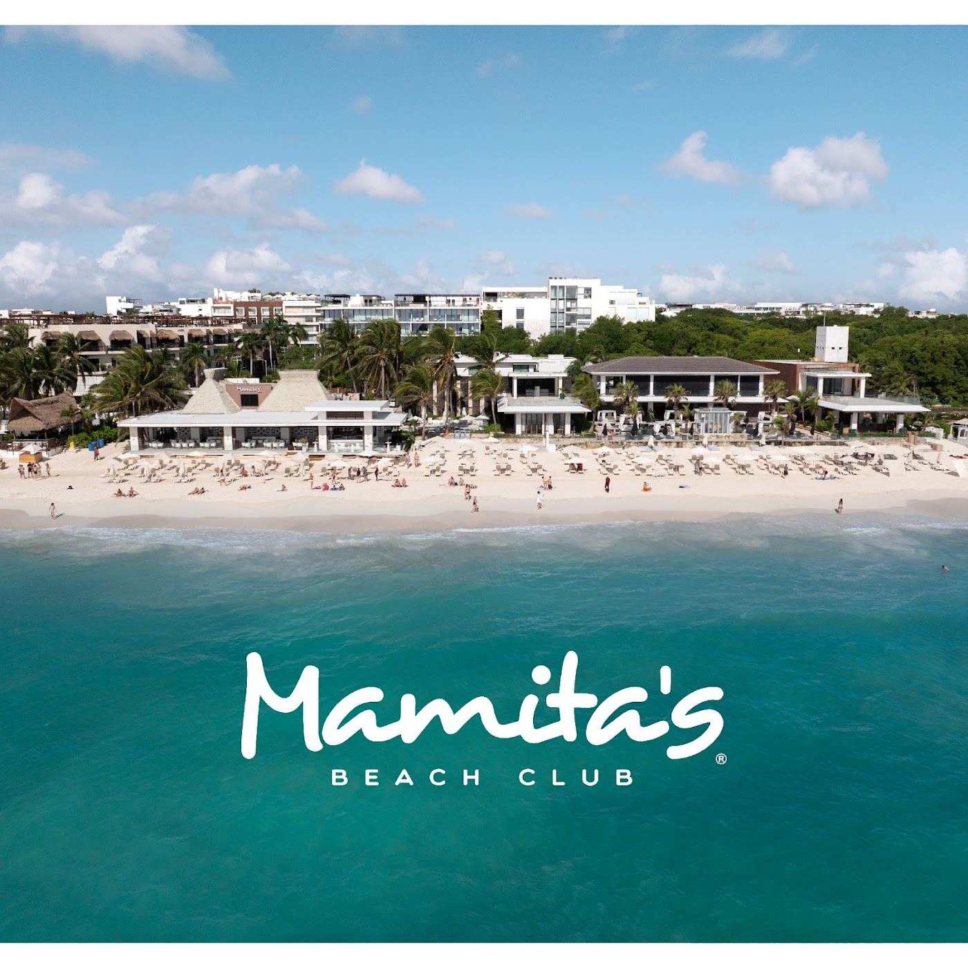 Loungers and turquoise Caribbean water at Mamita's Beach Club in Playa del Carmen