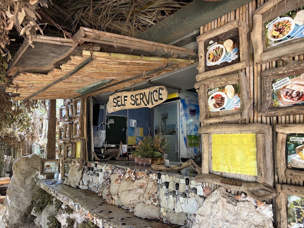 Bamboo shaded tables and swings at Safari Bar above the sea at Cape Kamenjak