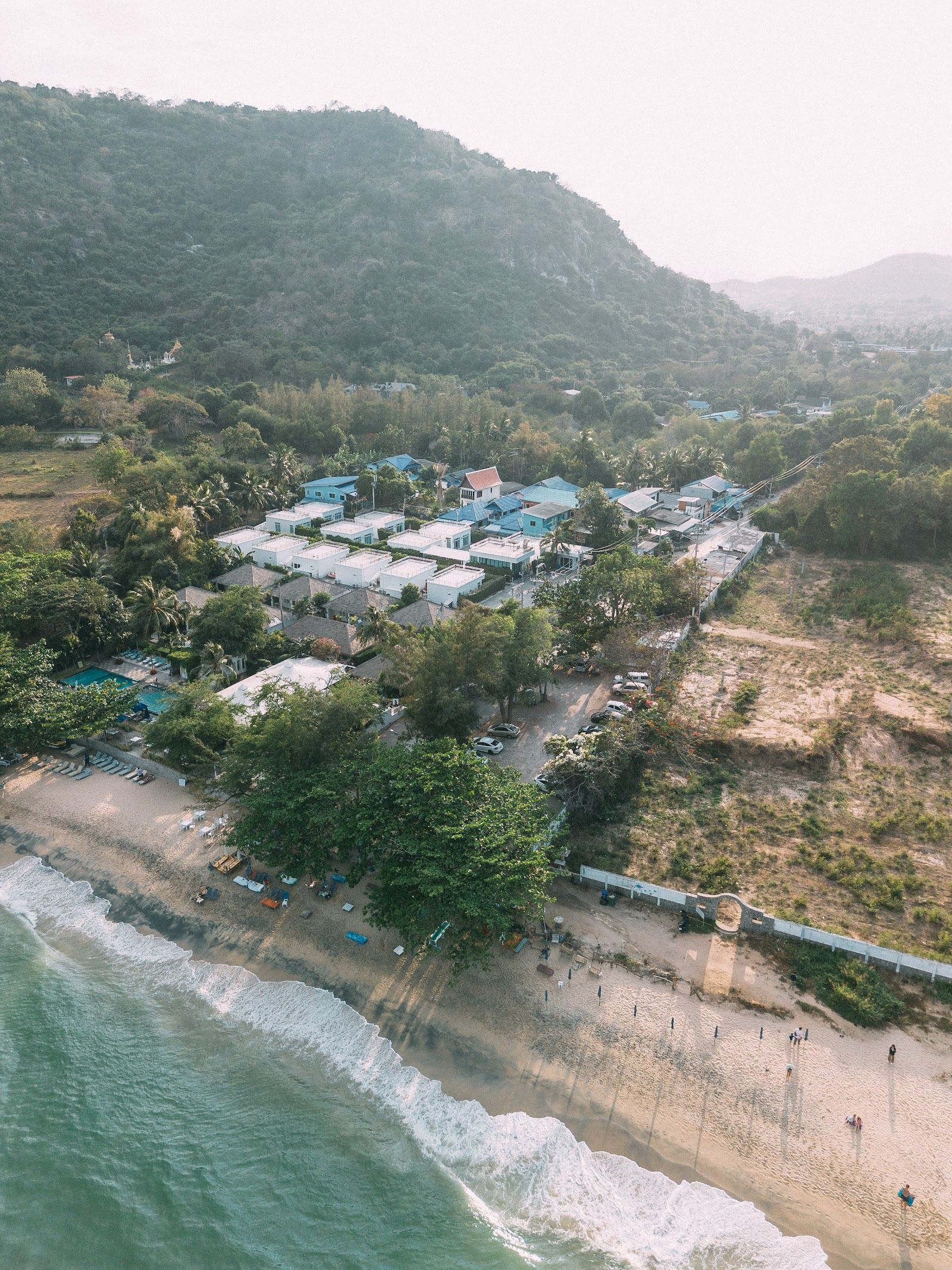 The sheltered cove of Sai Noi Beach below the wooded Khao Tao headland south of Hua Hin