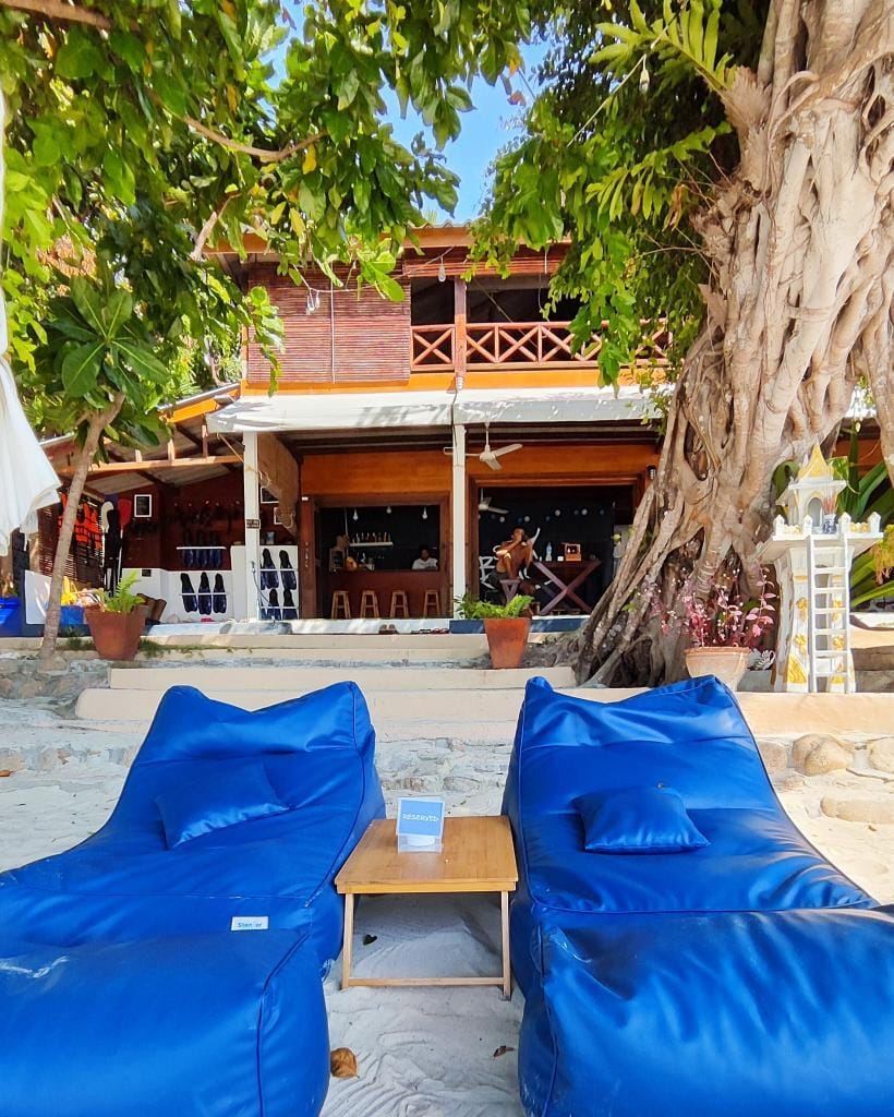 The quiet turquoise cove and pale sand of Sanom Beach tucked below green rocks on Koh Lipe