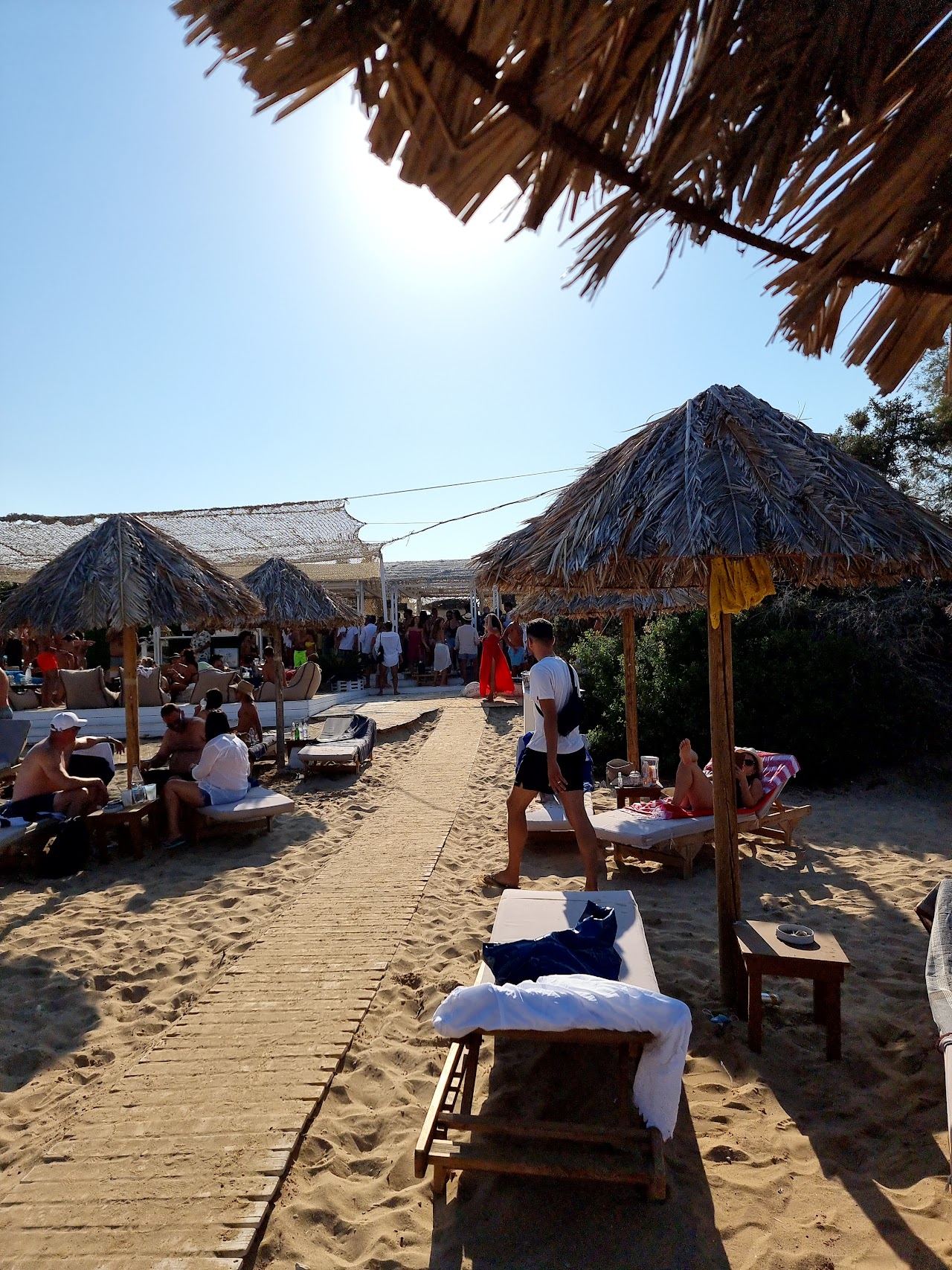 Loungers and umbrellas of the Santa Maria Beach Bar by the shallow water on the northeast coast of Paros