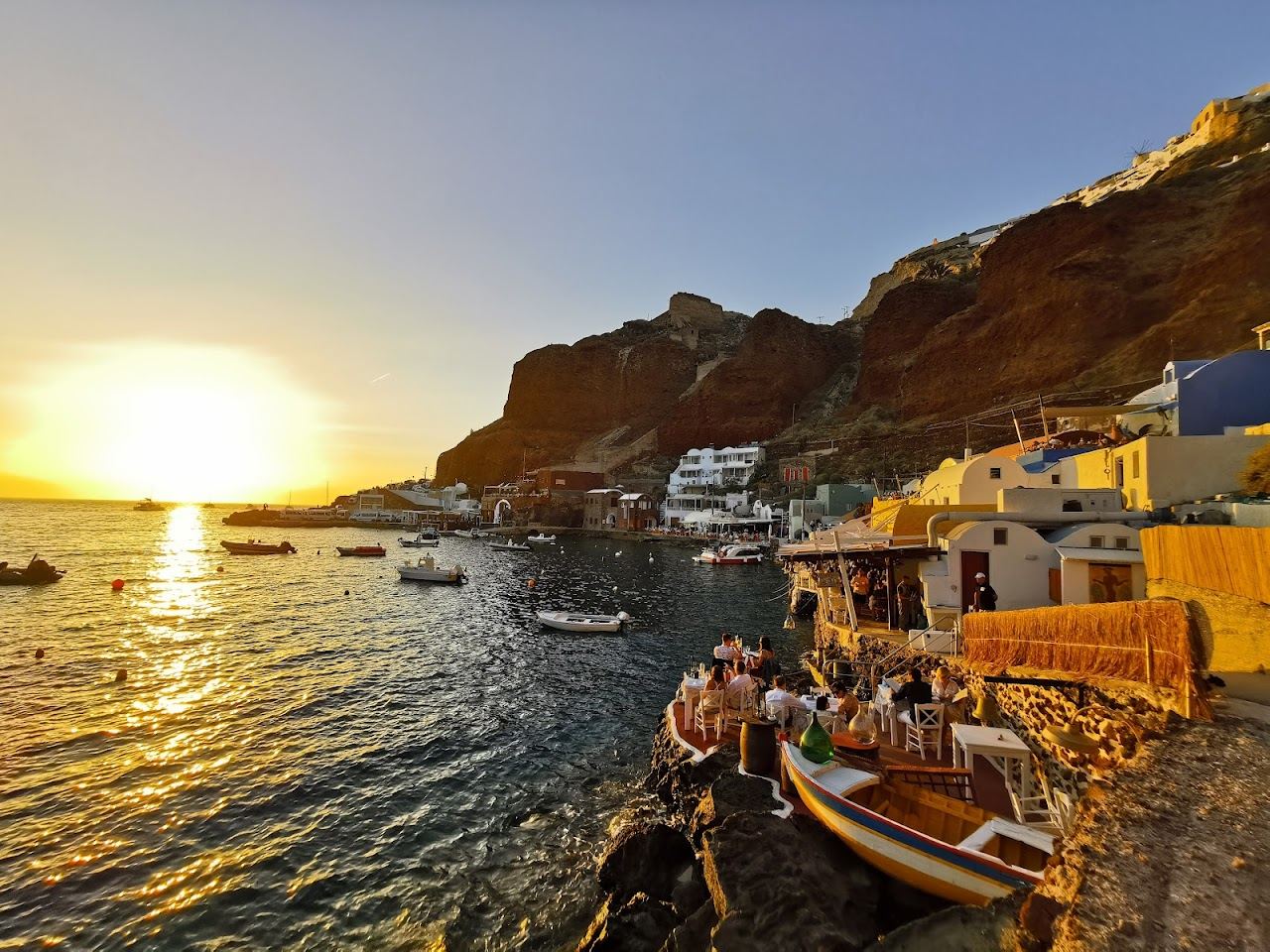 Warm evening light over the cliffs and water at Ammoudi Bay below Oia on Santorini