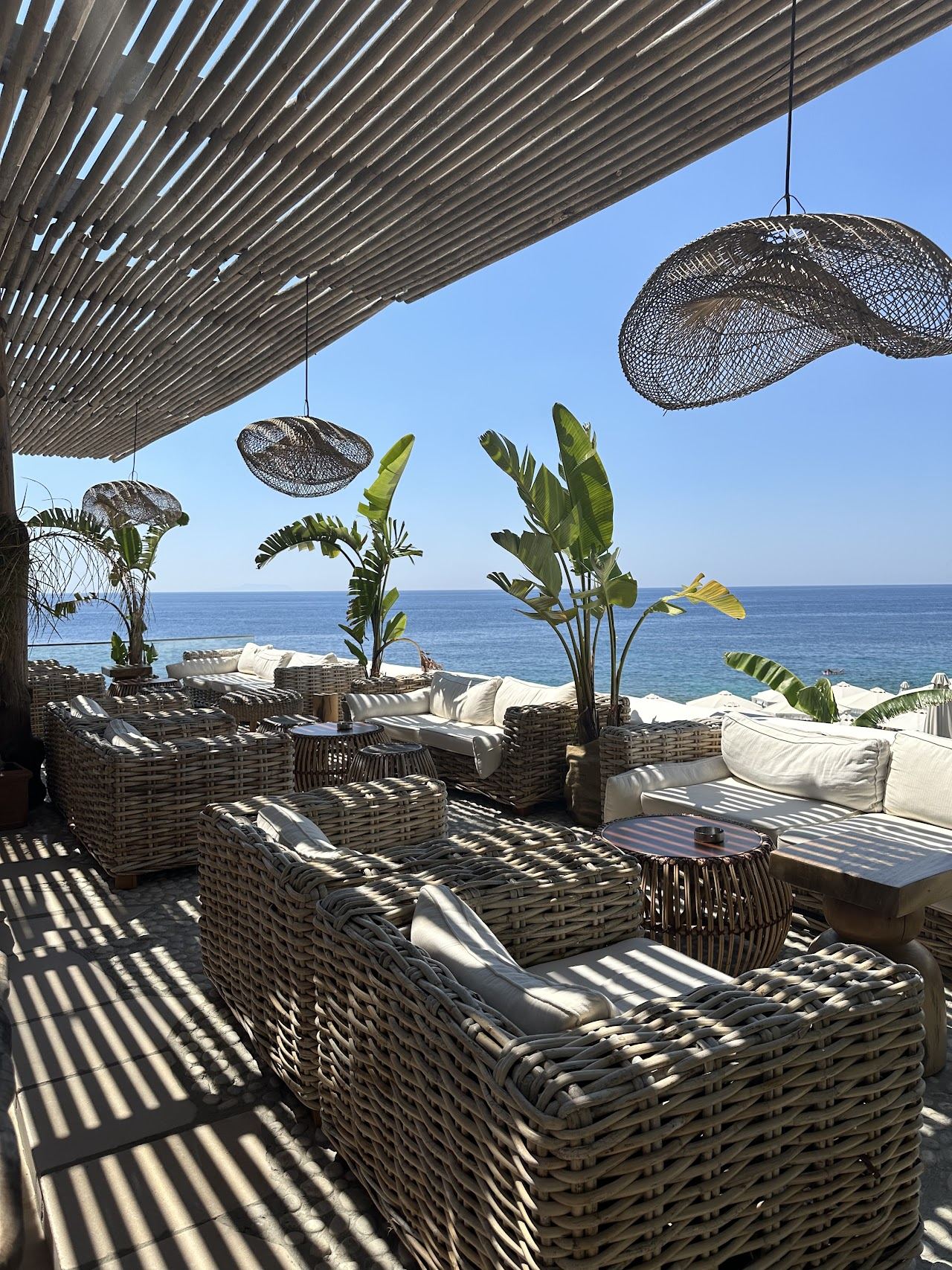 Bali inspired daybeds and thatch parasols at Sanur Beach House on the Dhermi shore of the Albanian Riviera