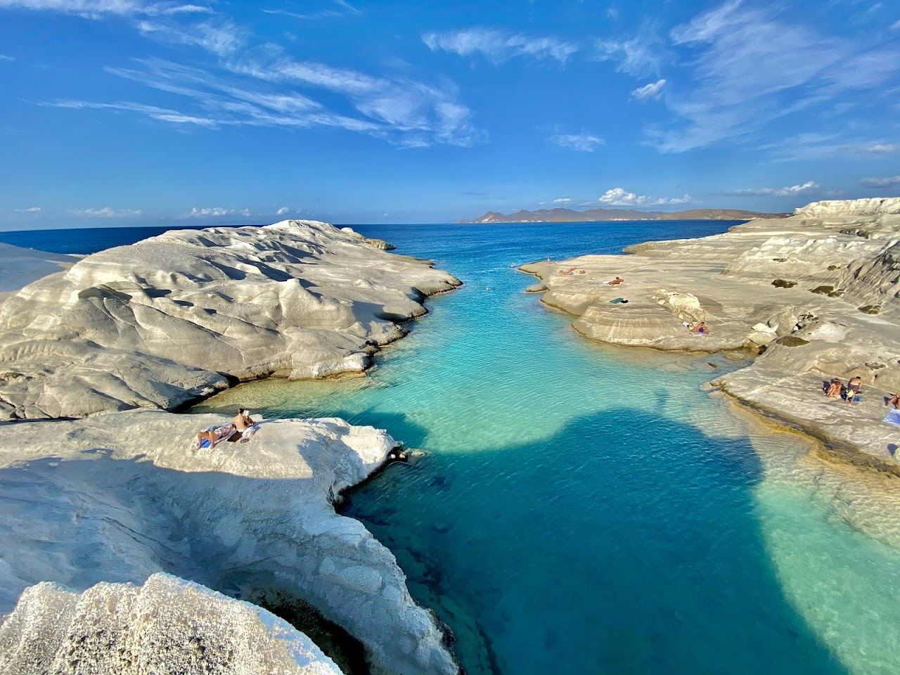 The smooth white volcanic rock and clear blue inlet of the lunar Sarakiniko landscape on the north coast of Milos