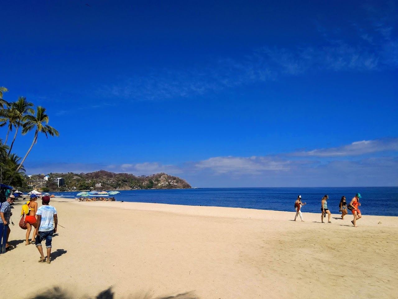 Golden sand, surfers and palm shade on the main beach at Sayulita in Nayarit Mexico