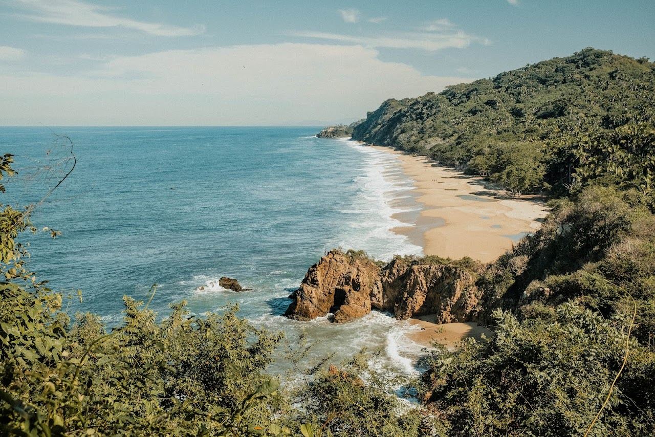 Rocky point and clear shallow water at Playa Las Cuevas near Sayulita
