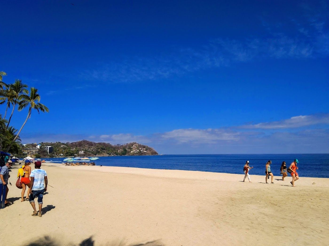 Surfers and palm shade along the main beach at Sayulita on the Nayarit coast of Mexico