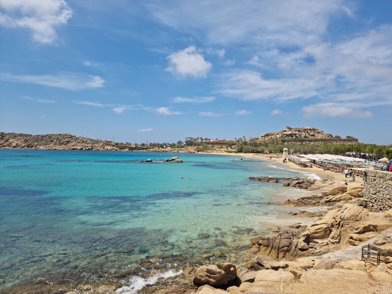 The sand crescent and clear water of Paraga beach beside the Scorpios headland
