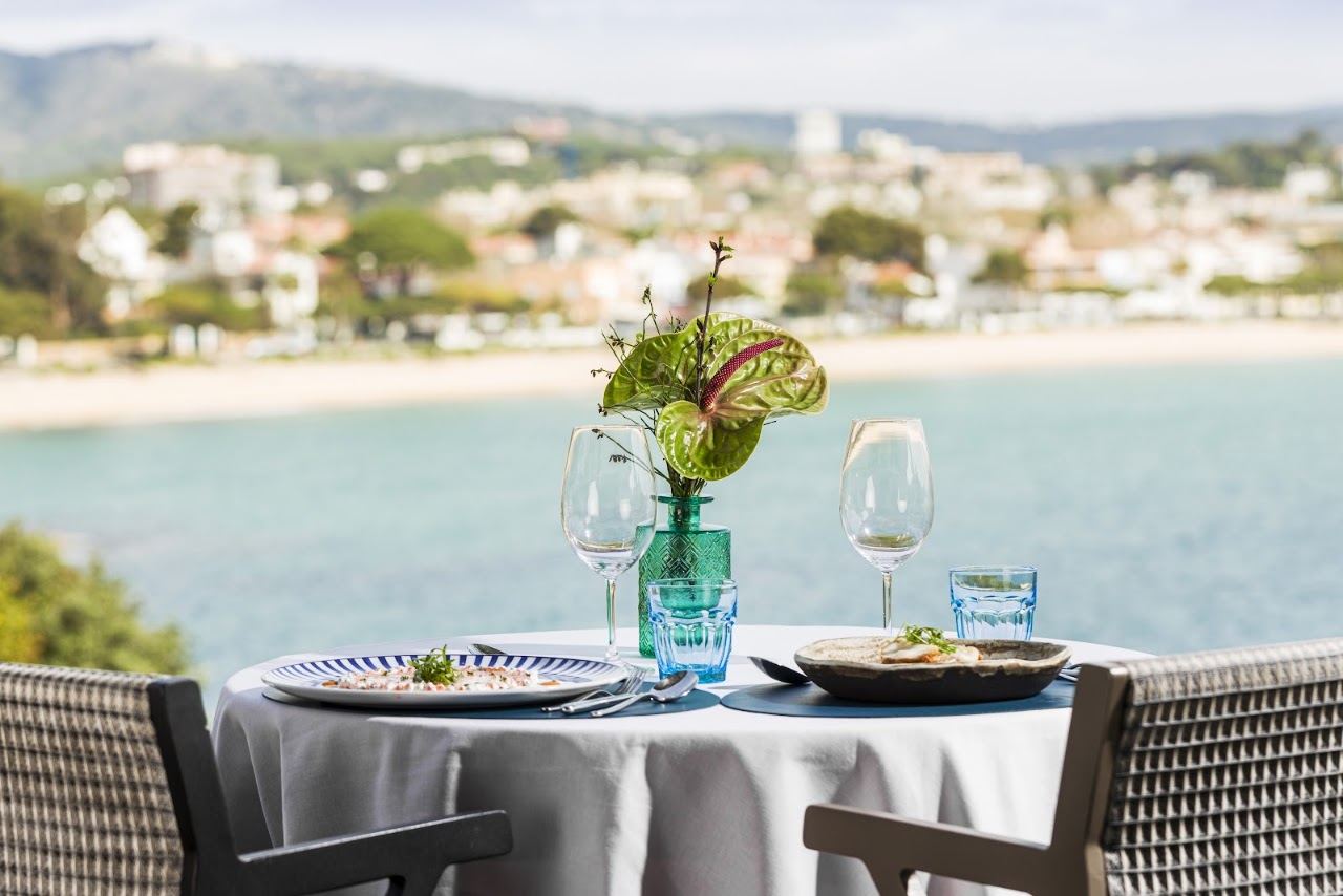The tiered terrace, infinity pool and cabanas of Sea Club Alabriga above the Bay of Sant Pol on the Costa Brava