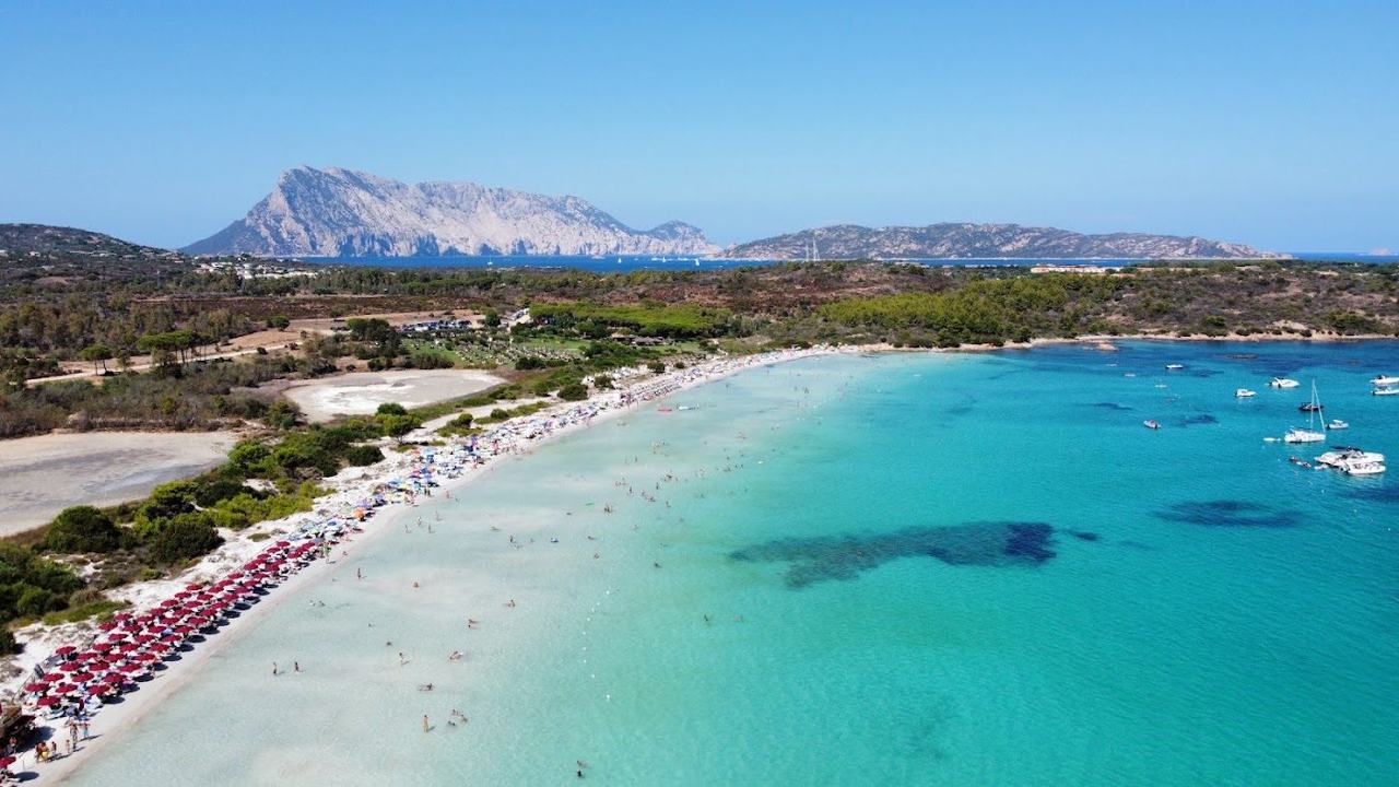 Calm warm shallows and pale sand on a quiet Sardinian beach in September light