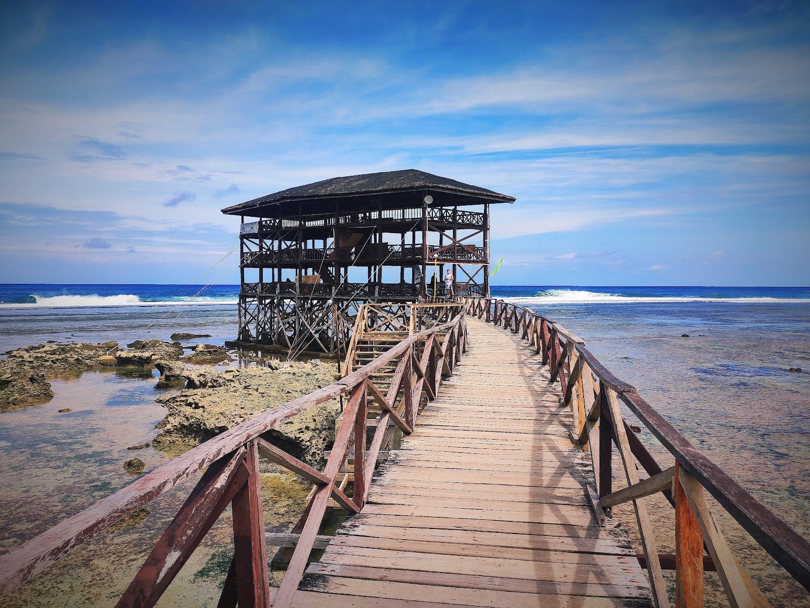 A surfer riding the famous Cloud 9 reef break off the Siargao boardwalk