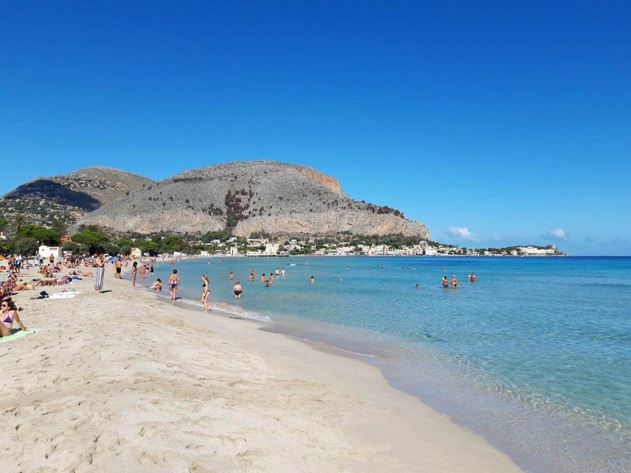 Sunbeds and clear water at a Mondello bathing house on the white sand bay near Palermo, Sicily