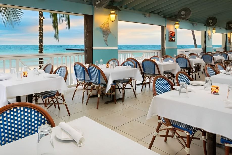 Tables and umbrellas beside the sand at Southernmost Beach Cafe on South Beach in Key West