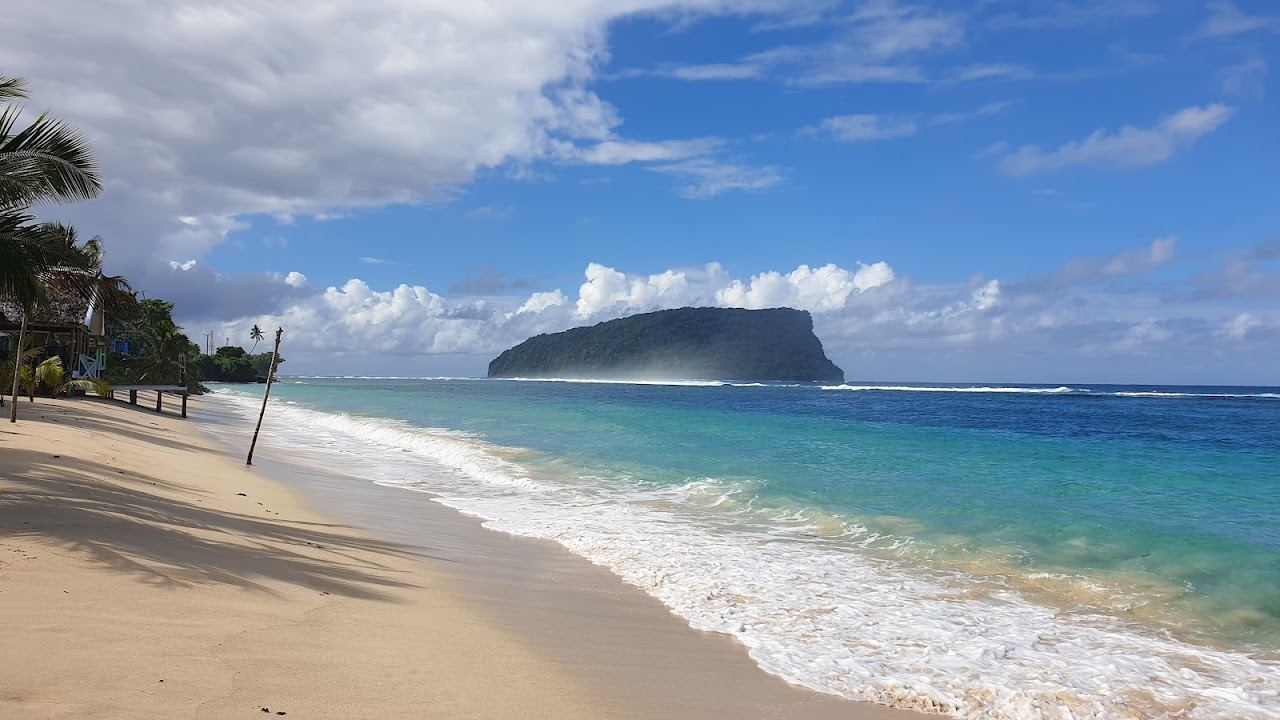 Thatched beach fales along the sand at Lalomanu Beach in Samoa