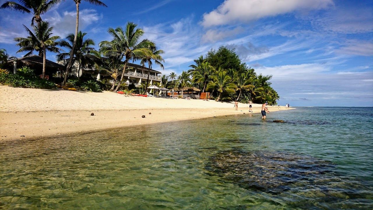 The calm clear lagoon and white sand of Titikaveka Beach on Rarotonga