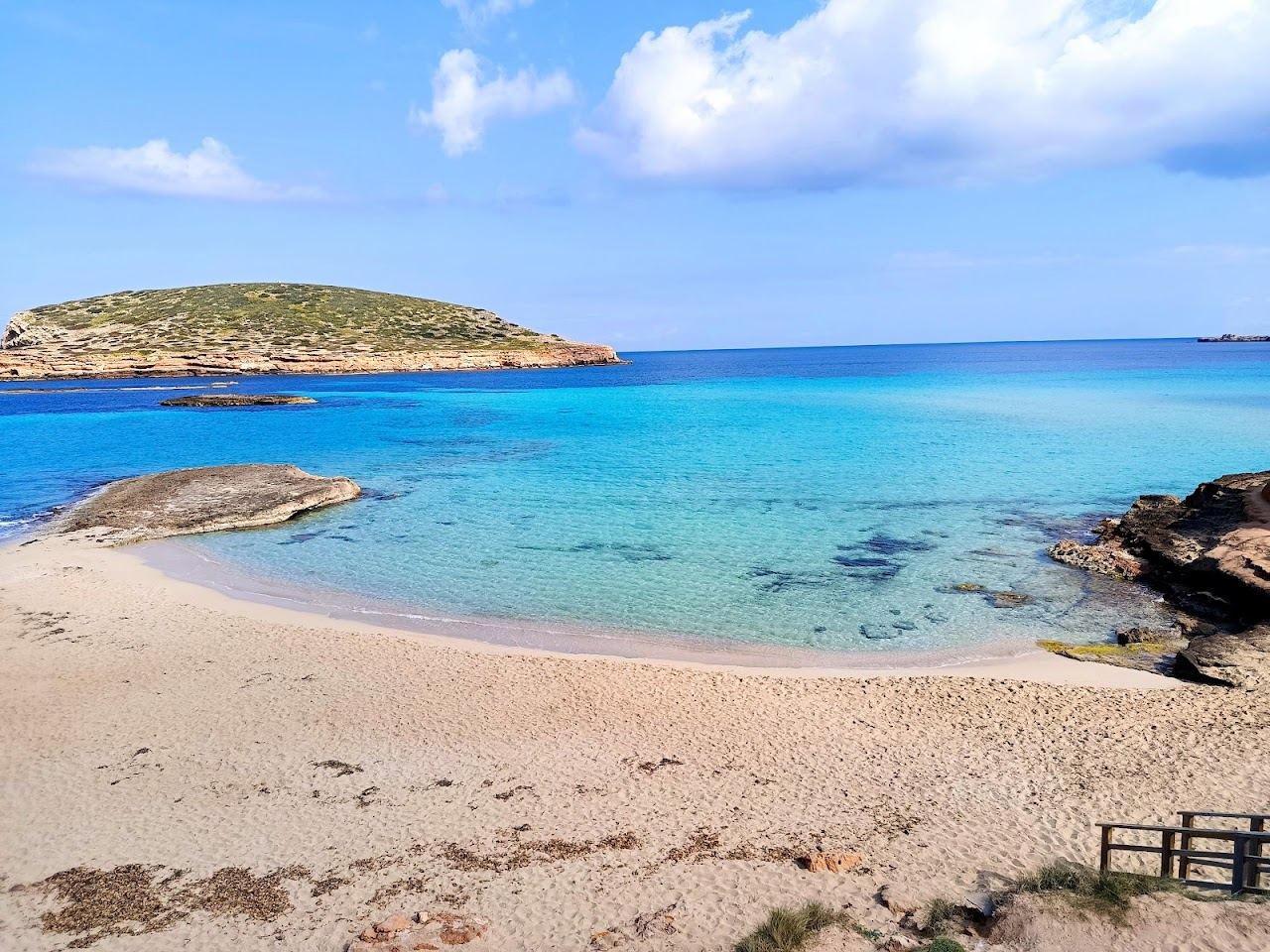 The turquoise water and pale sand of Cala Comte on Ibiza