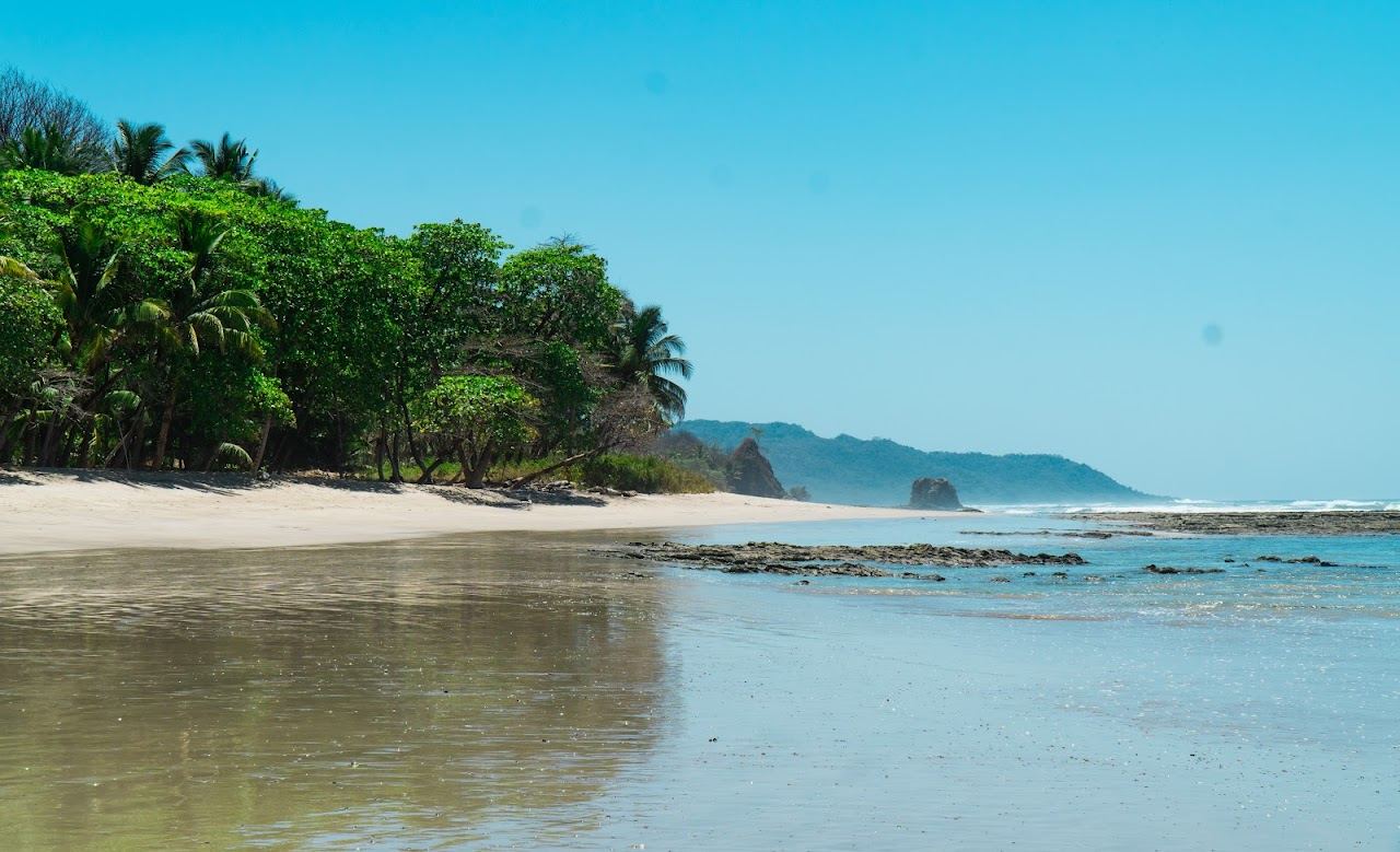 Warm low sun over the wide Pacific sand at Santa Teresa Costa Rica