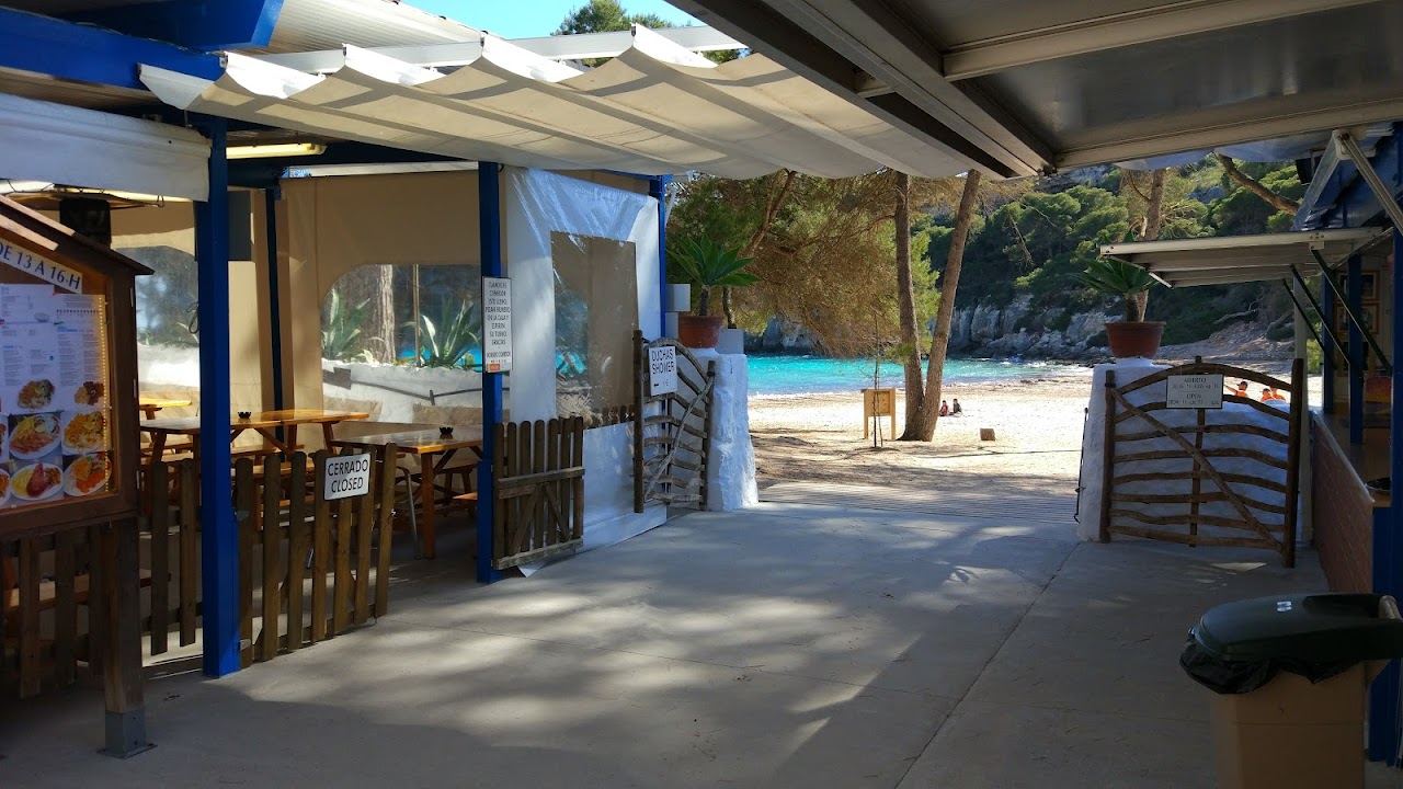 The shaded terrace of the Susy beach bar above the turquoise water of Cala Macarella in Menorca