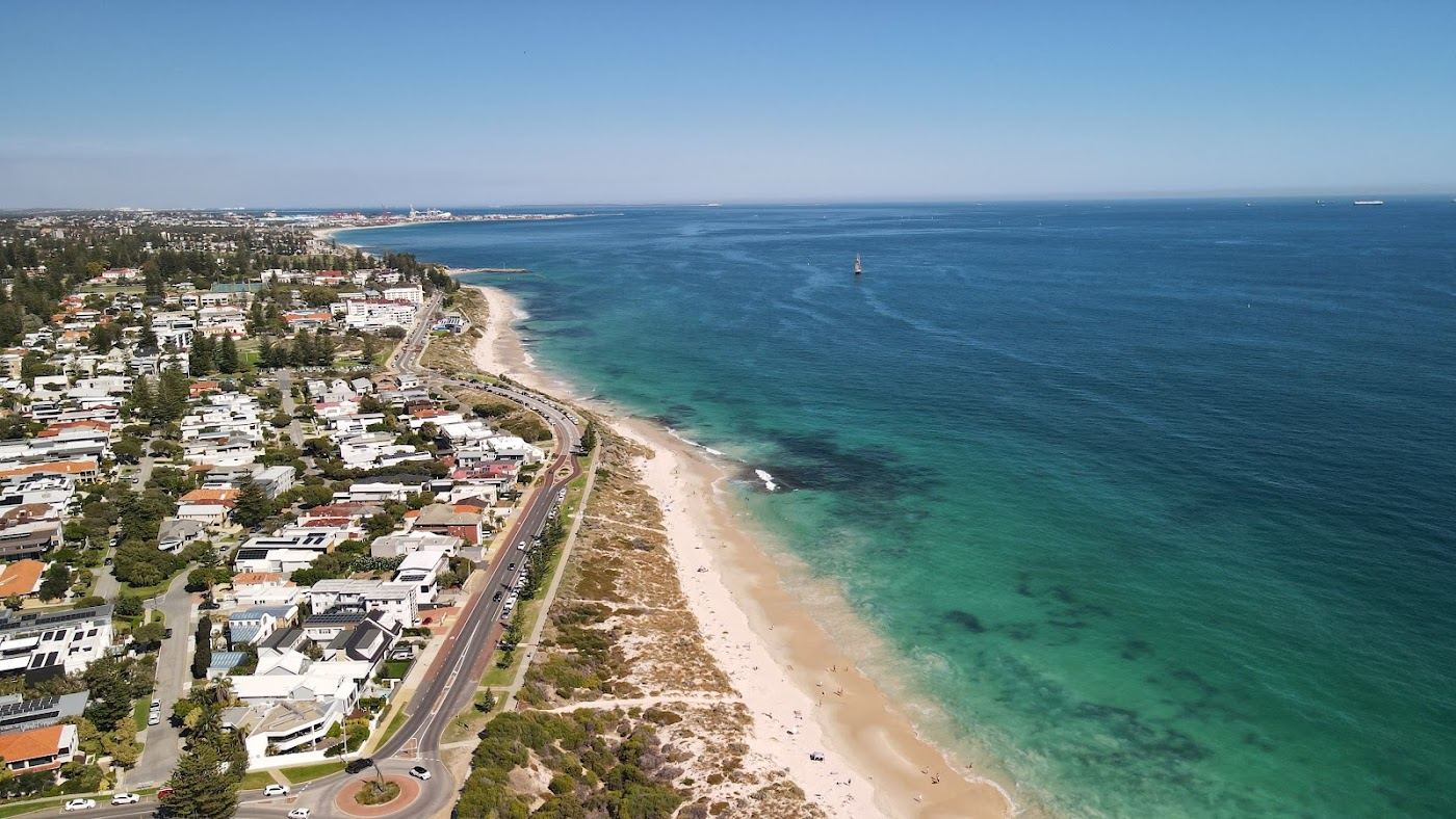 The wide golden sand, natural dunes and calm morning water of Swanbourne Beach in the western suburbs of Perth