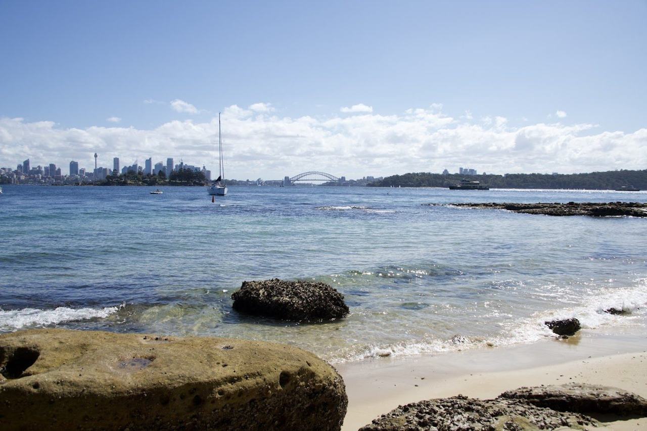 The hidden harbour cove at Milk Beach in Vaucluse with the Sydney city skyline across the water