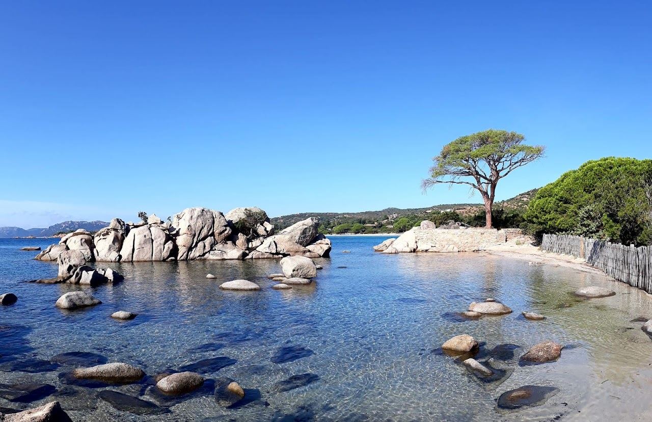 Turquoise water and pale sand along the Tamaricciu stretch of Palombaggia bay with granite at the shoreline