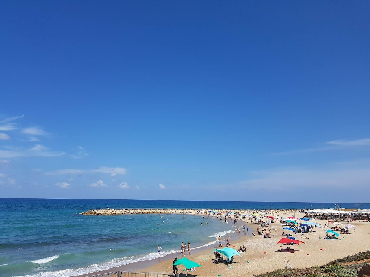 The sheltered bay, sunbeds and soft sand of Tel Baruch beach in north Tel Aviv