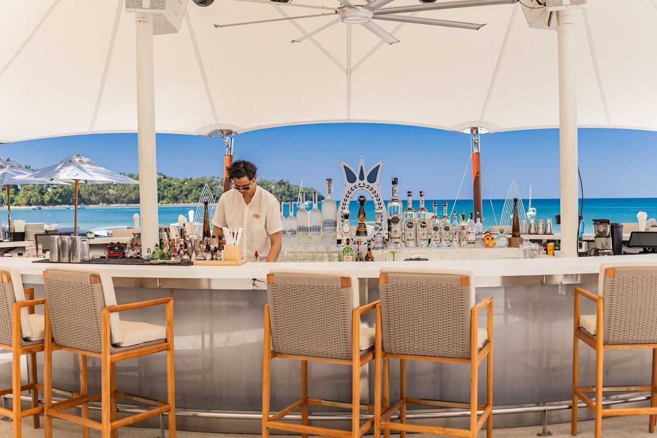 Daybeds and an infinity pool above the sand at a beach club on Bang Tao Beach, Phuket, Thailand