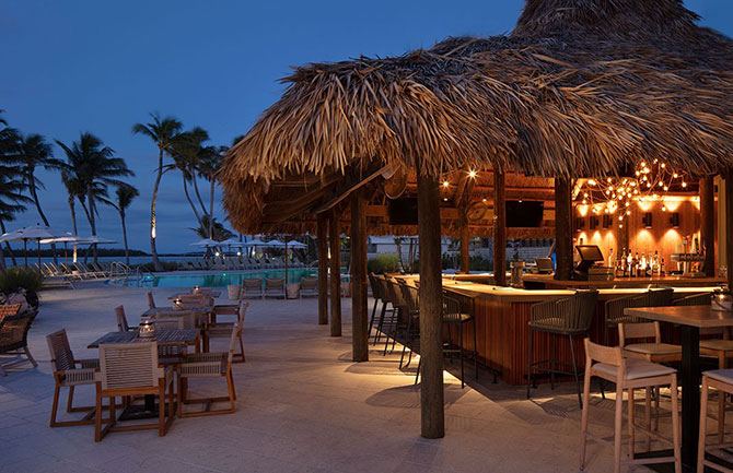 Palm shaded poolside Tiki Bar at Amara Cay Resort with the ocean beyond in Islamorada