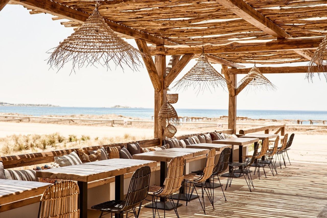 Bamboo shaded sunbeds and reed umbrellas at Tortuga on Plaka beach in Naxos