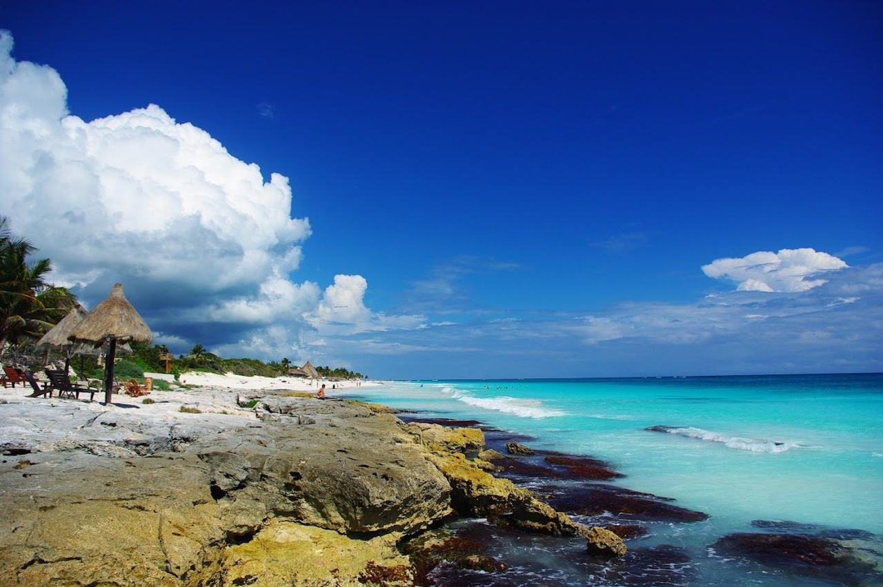Calm turquoise shallows and pale sand on the Tulum coast in Mexico