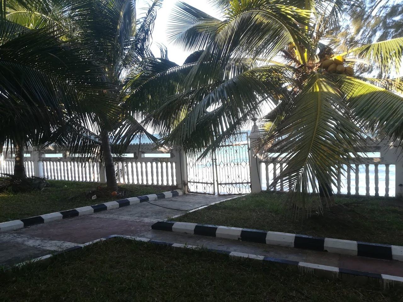 White sand, fishing dhows and a calm turquoise lagoon along the village shore at Uroa on the east coast of Zanzibar